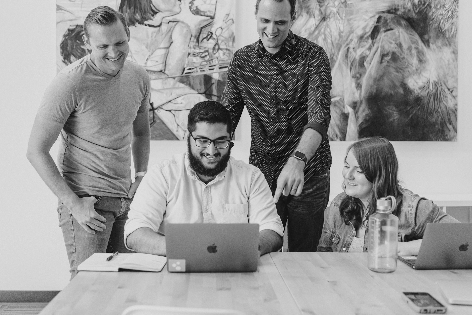 A team working together around a laptop