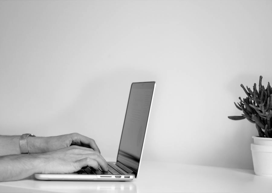 Hands typing on a laptop
